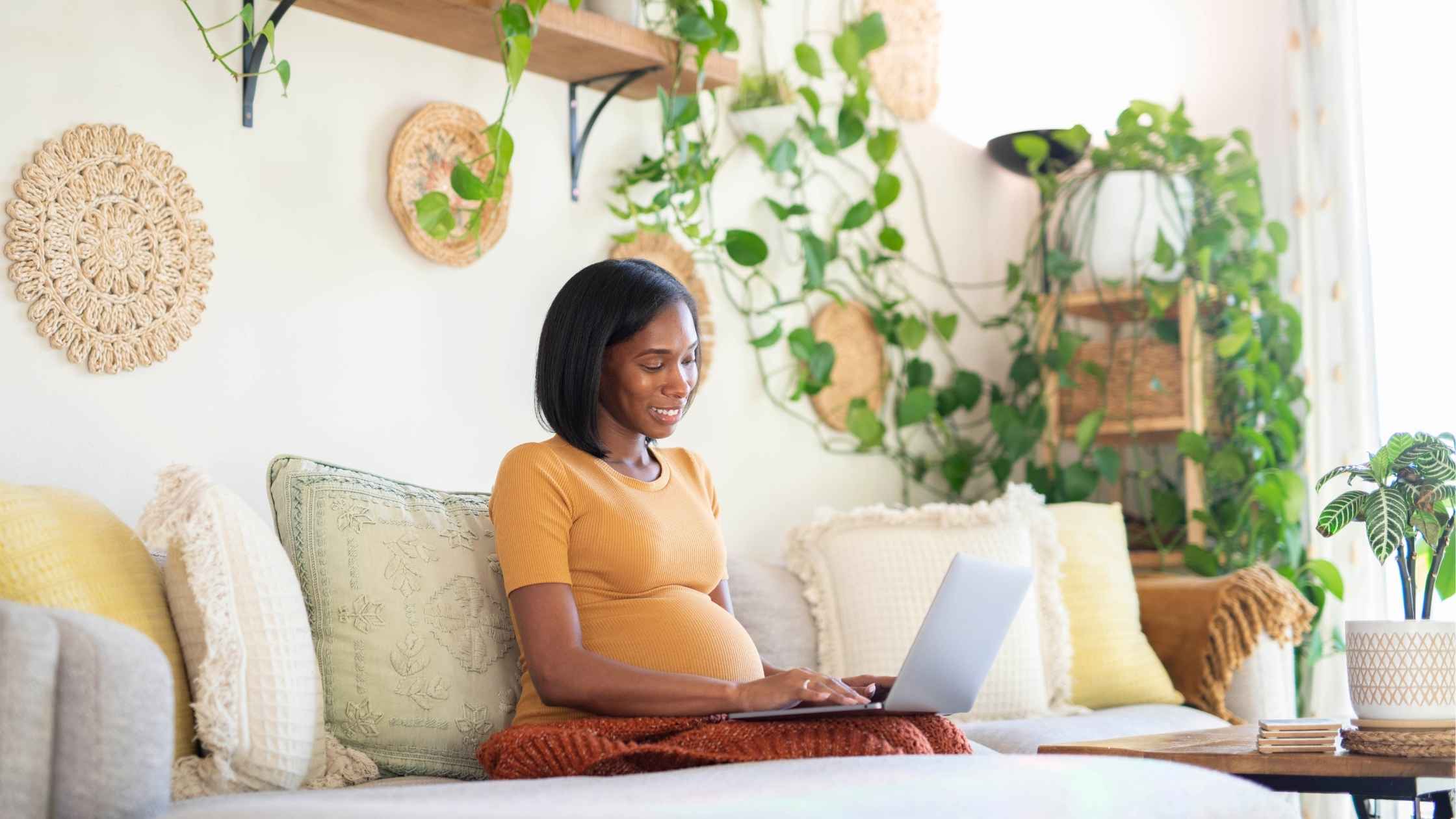 pregnant mom adding postpartum items to her baby registry on her laptop