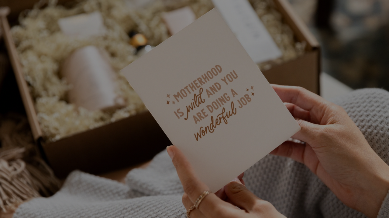 A postpartum gift box for a new mom featuring a handwritten card and curated high-quality products.
