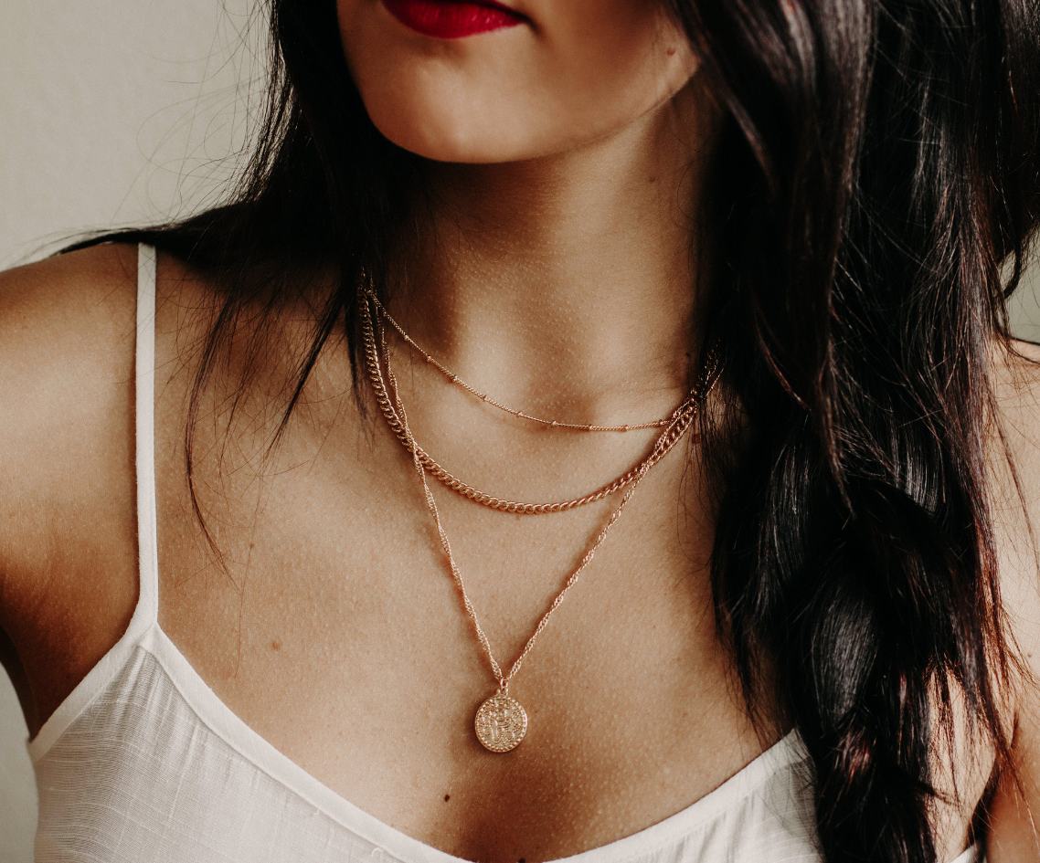 woman in a white tank top wearing a necklace