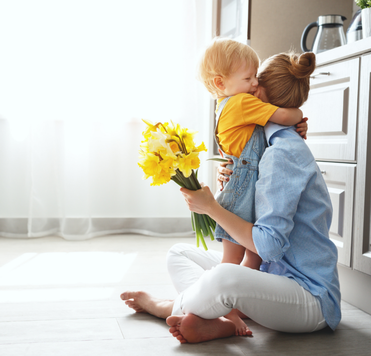 mom hugging her son with flowers