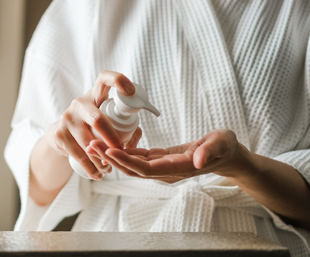 new mom using skincare products in her robe