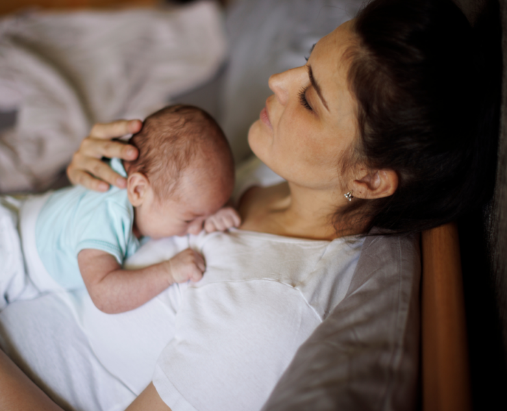 new mom snuggling her newborn baby on her chest